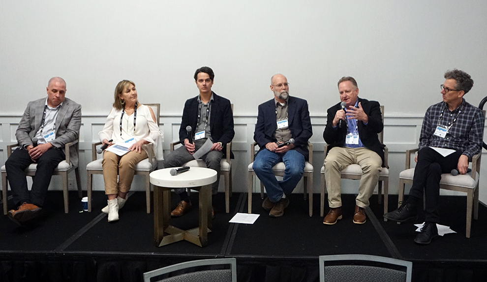 Six seated panelists in discussion