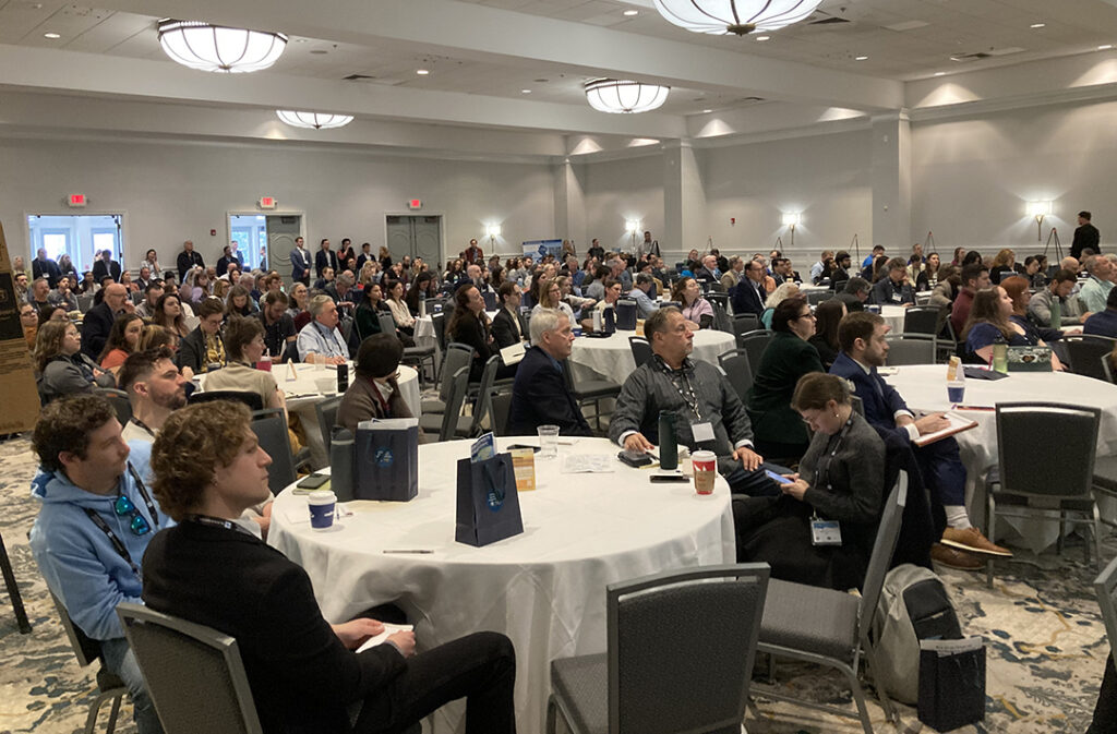 A large audeince in an auditorium watching presentations
